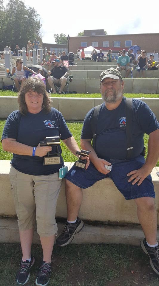 Two men in navy polo shirts at community event