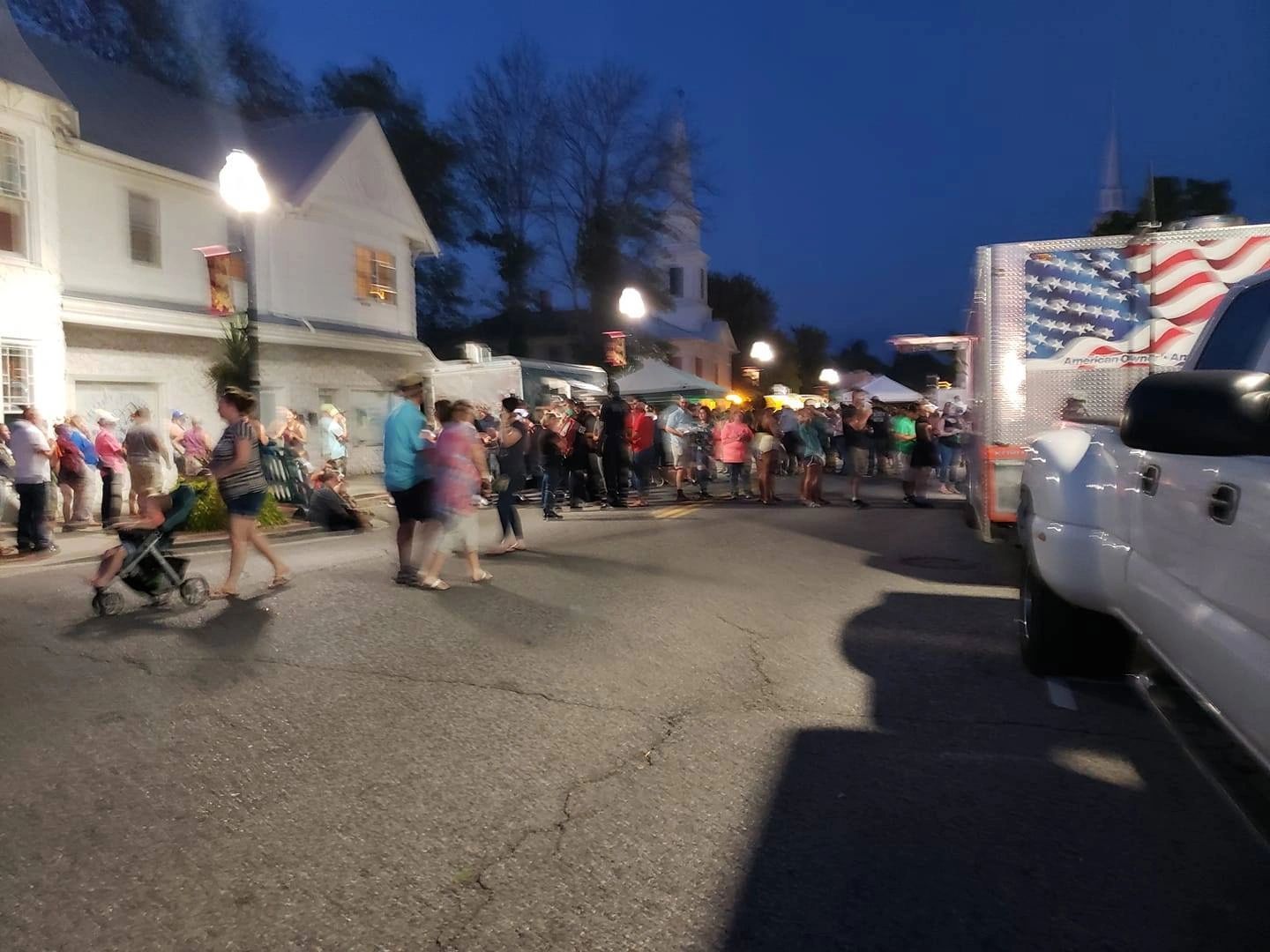 Community festival at twilight with American flag